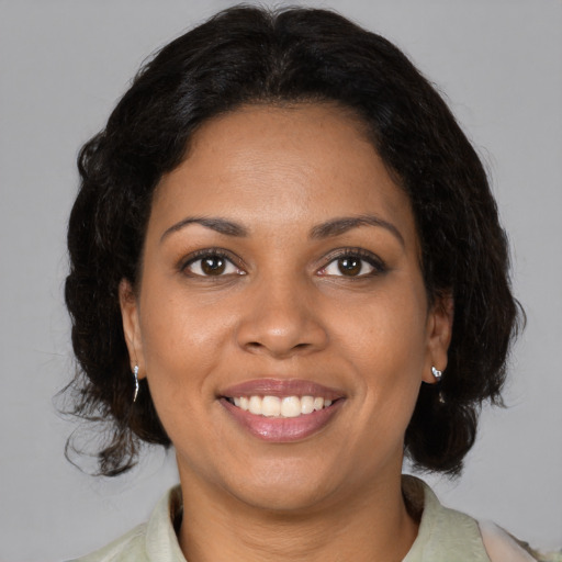 Joyful black adult female with medium  brown hair and brown eyes