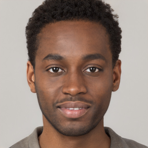 Joyful black young-adult male with short  brown hair and brown eyes