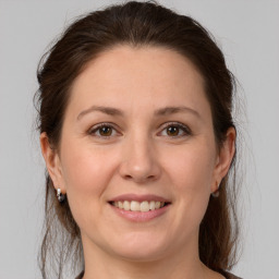 Joyful white young-adult female with medium  brown hair and grey eyes