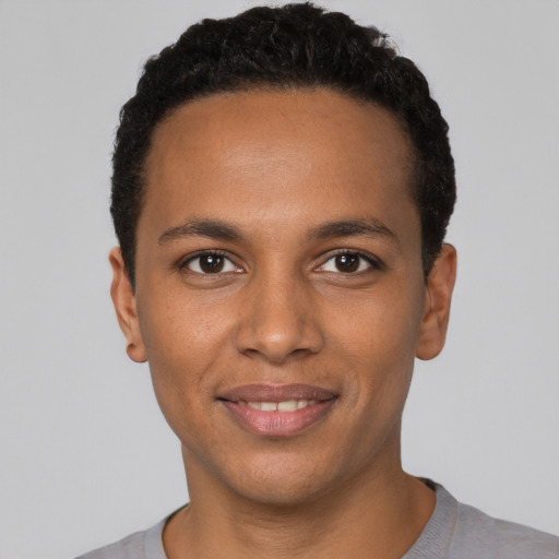 Joyful black young-adult male with short  black hair and brown eyes