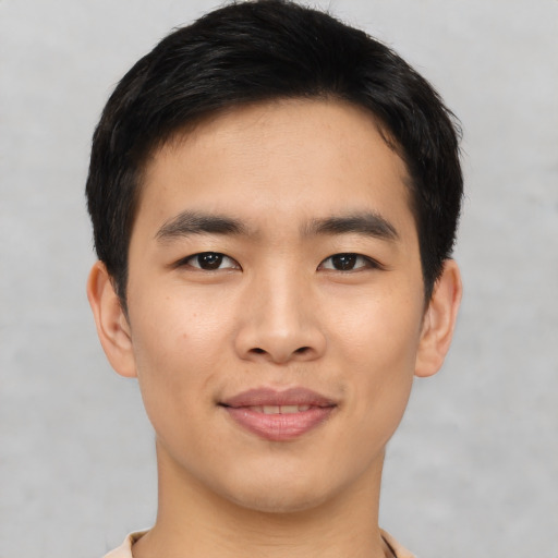Joyful asian young-adult male with short  black hair and brown eyes