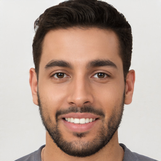 Joyful white young-adult male with short  black hair and brown eyes