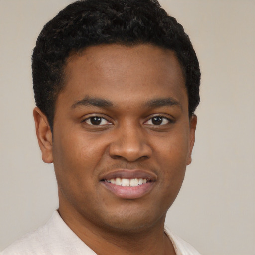 Joyful black young-adult male with short  brown hair and brown eyes