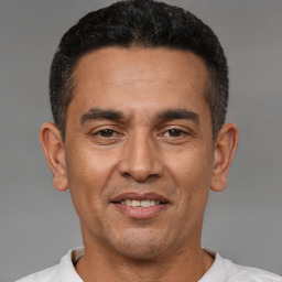 Joyful latino adult male with short  black hair and brown eyes