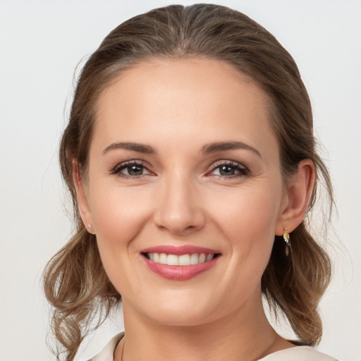 Joyful white young-adult female with medium  brown hair and grey eyes