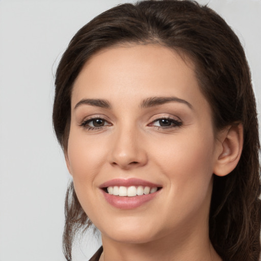 Joyful white young-adult female with long  brown hair and brown eyes