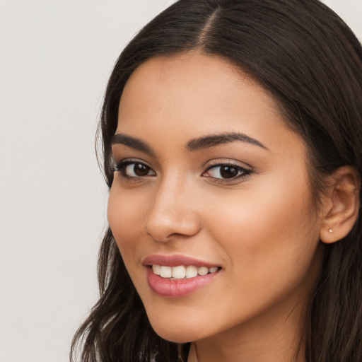 Joyful latino young-adult female with long  brown hair and brown eyes