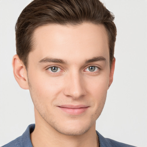 Joyful white young-adult male with short  brown hair and grey eyes