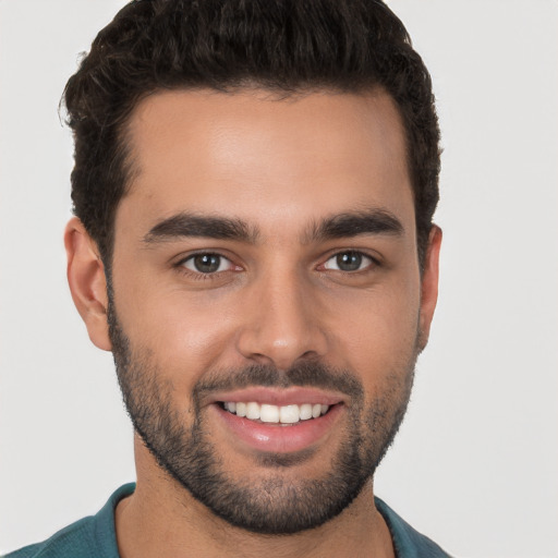 Joyful white young-adult male with short  black hair and brown eyes