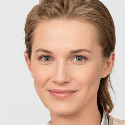 Joyful white young-adult female with medium  brown hair and grey eyes