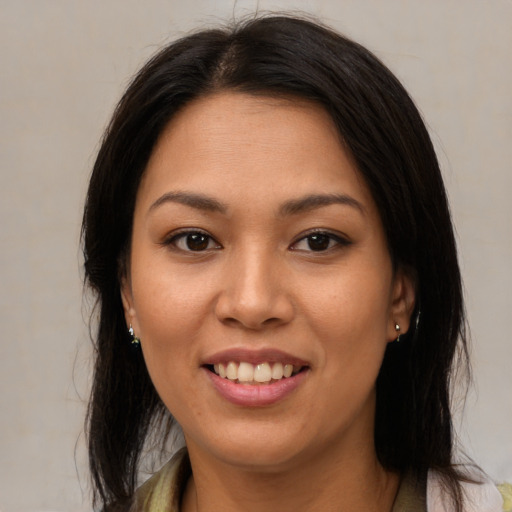 Joyful latino young-adult female with medium  brown hair and brown eyes