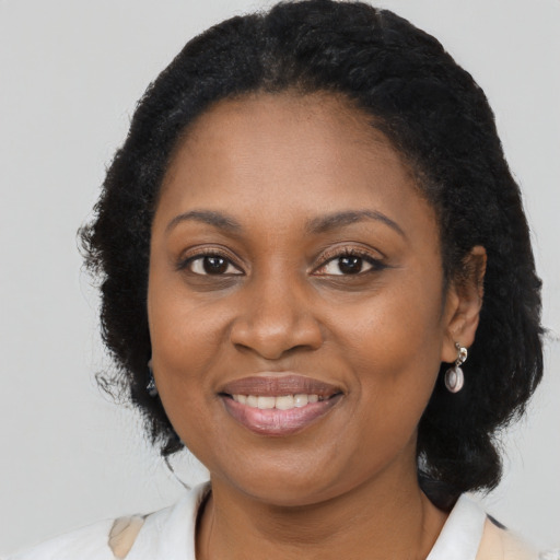 Joyful black adult female with long  brown hair and brown eyes