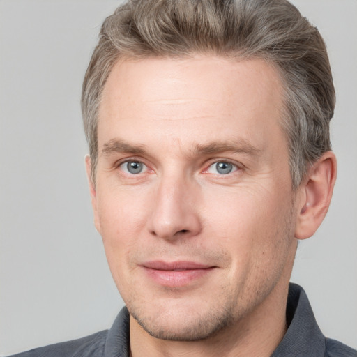 Joyful white adult male with short  brown hair and grey eyes