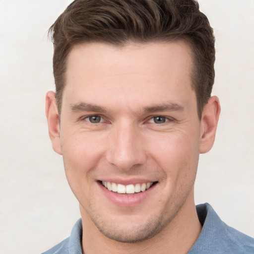 Joyful white young-adult male with short  brown hair and grey eyes