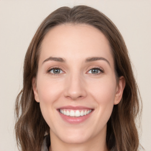 Joyful white young-adult female with long  brown hair and grey eyes