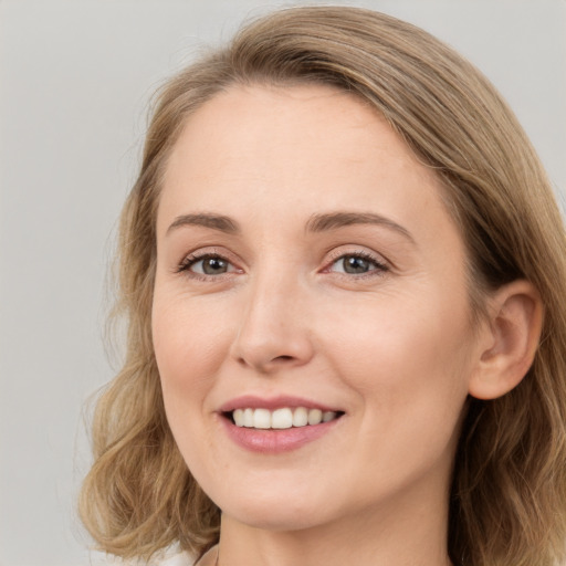 Joyful white young-adult female with long  brown hair and green eyes