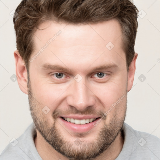 Joyful white young-adult male with short  brown hair and grey eyes