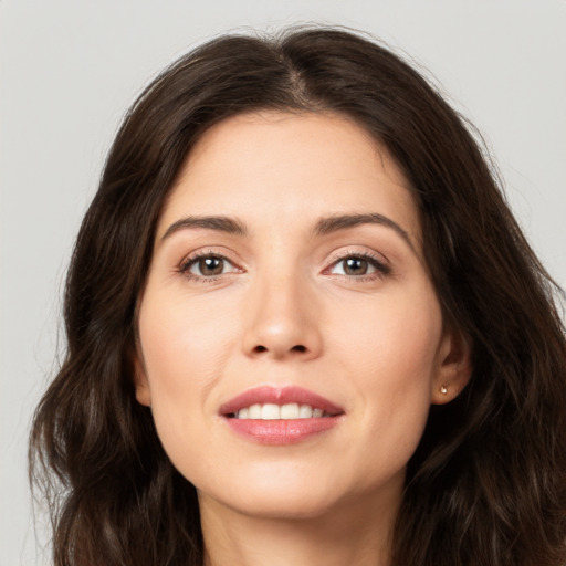 Joyful white young-adult female with long  brown hair and brown eyes