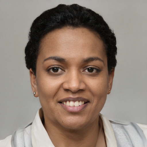 Joyful black young-adult female with short  black hair and brown eyes