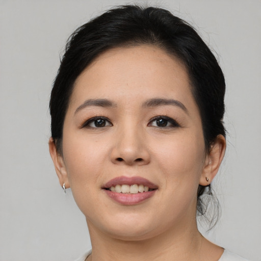 Joyful asian young-adult female with short  black hair and brown eyes