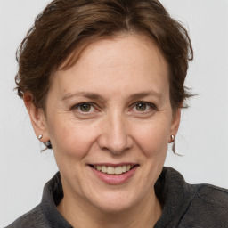 Joyful white adult female with medium  brown hair and grey eyes