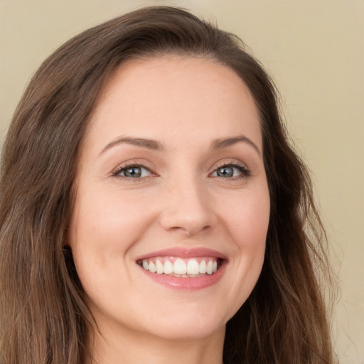 Joyful white young-adult female with long  brown hair and green eyes