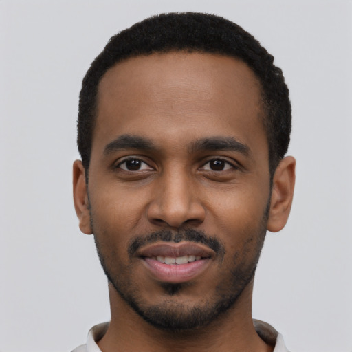 Joyful black young-adult male with short  black hair and brown eyes
