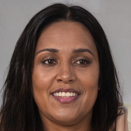 Joyful latino adult female with long  brown hair and brown eyes