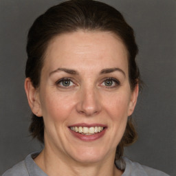 Joyful white adult female with medium  brown hair and grey eyes