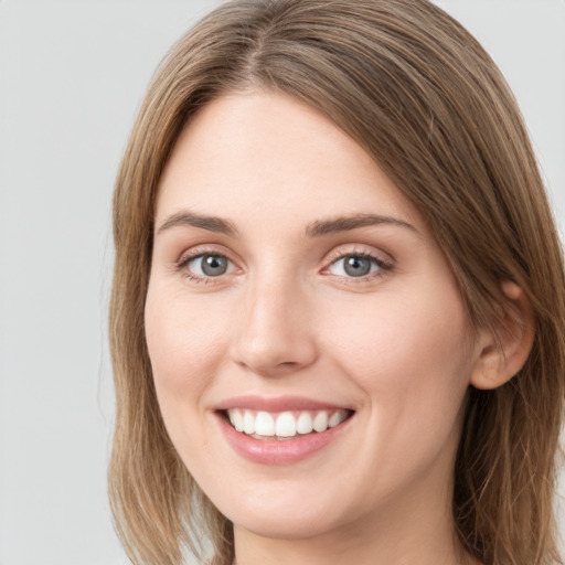 Joyful white young-adult female with long  brown hair and blue eyes