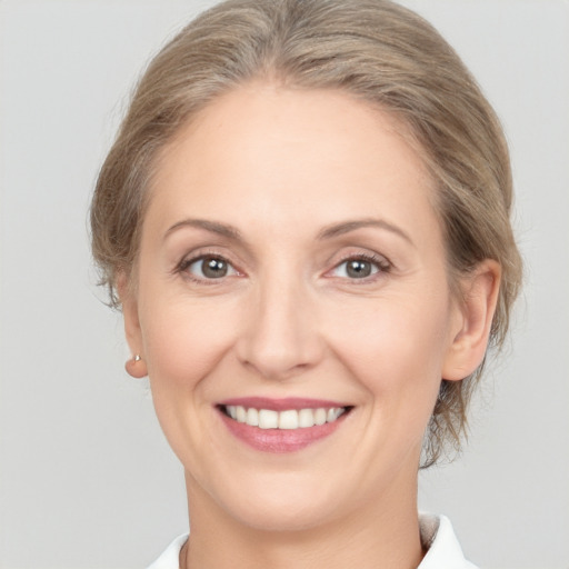 Joyful white young-adult female with medium  brown hair and grey eyes