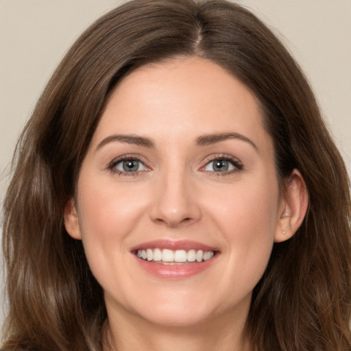 Joyful white young-adult female with long  brown hair and green eyes