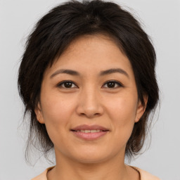 Joyful asian young-adult female with medium  brown hair and brown eyes