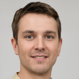 Joyful white young-adult male with short  brown hair and grey eyes