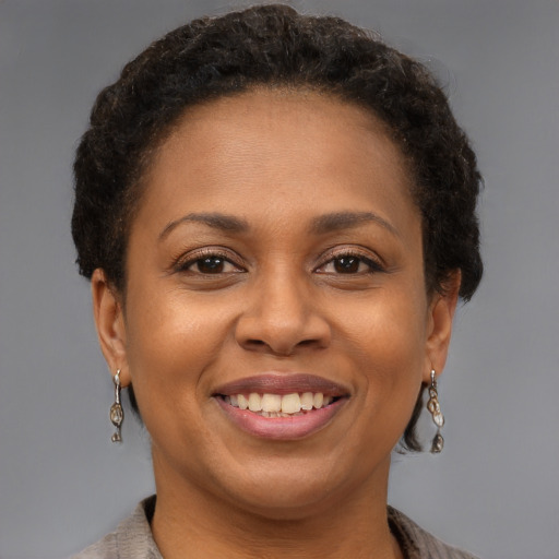Joyful black adult female with short  brown hair and brown eyes