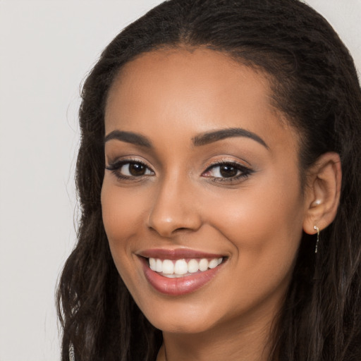 Joyful latino young-adult female with long  brown hair and brown eyes