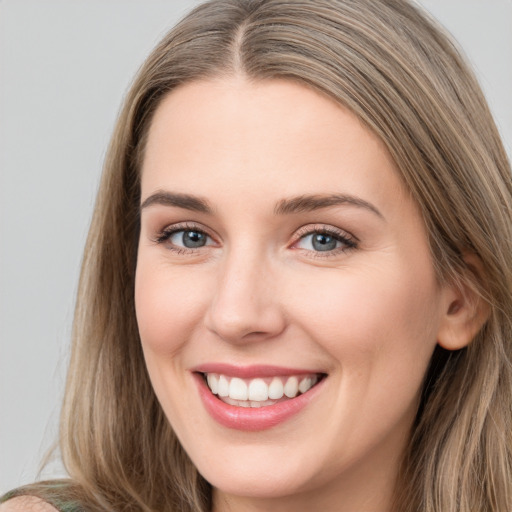 Joyful white young-adult female with long  brown hair and grey eyes