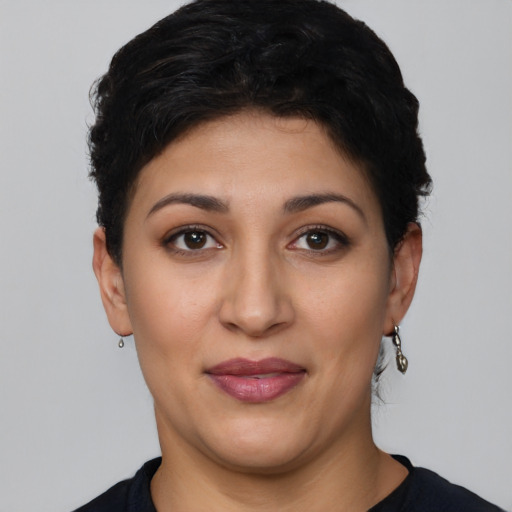 Joyful latino young-adult female with short  black hair and brown eyes