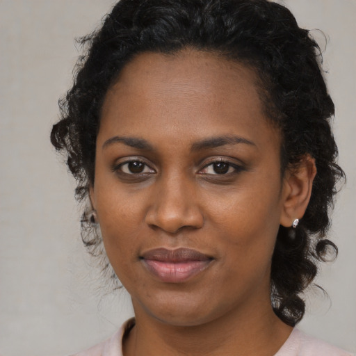 Joyful black young-adult female with medium  black hair and brown eyes