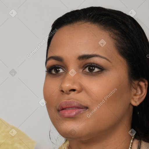 Joyful black young-adult female with long  black hair and brown eyes