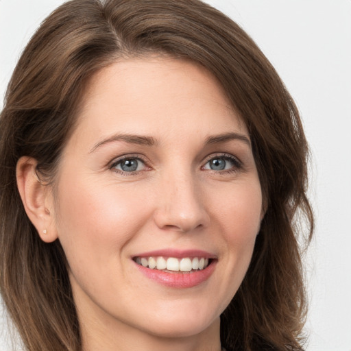 Joyful white young-adult female with long  brown hair and grey eyes