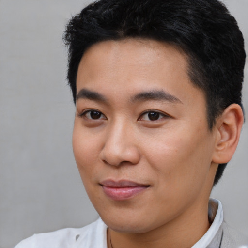 Joyful asian young-adult male with short  brown hair and brown eyes