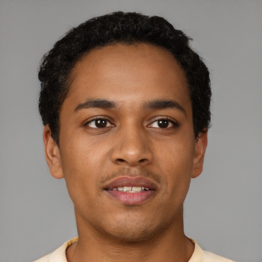 Joyful black young-adult male with short  brown hair and brown eyes