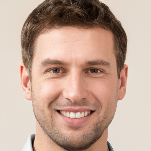 Joyful white young-adult male with short  brown hair and brown eyes