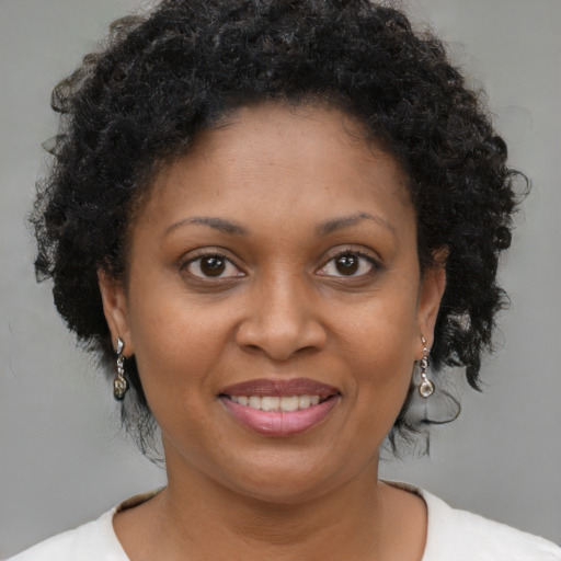 Joyful black young-adult female with short  brown hair and brown eyes