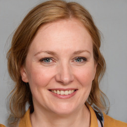 Joyful white adult female with medium  brown hair and blue eyes