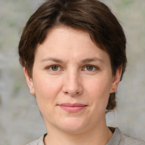 Joyful white adult female with medium  brown hair and grey eyes