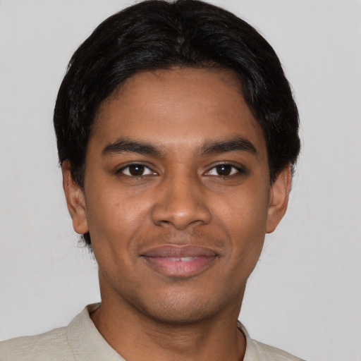Joyful black young-adult male with short  black hair and brown eyes