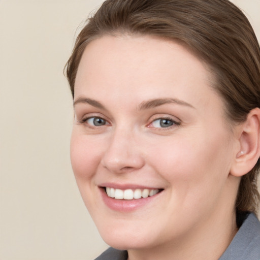 Joyful white young-adult female with medium  brown hair and blue eyes