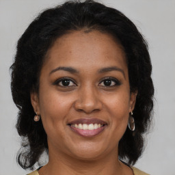 Joyful black adult female with medium  brown hair and brown eyes